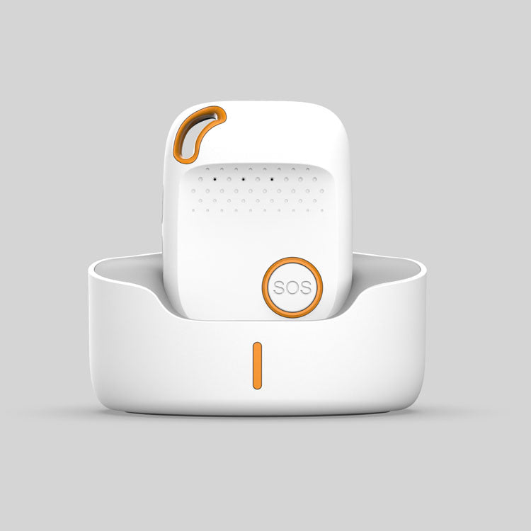 White and orange personal alarm device with SOS button placed upright in a matching charging dock.